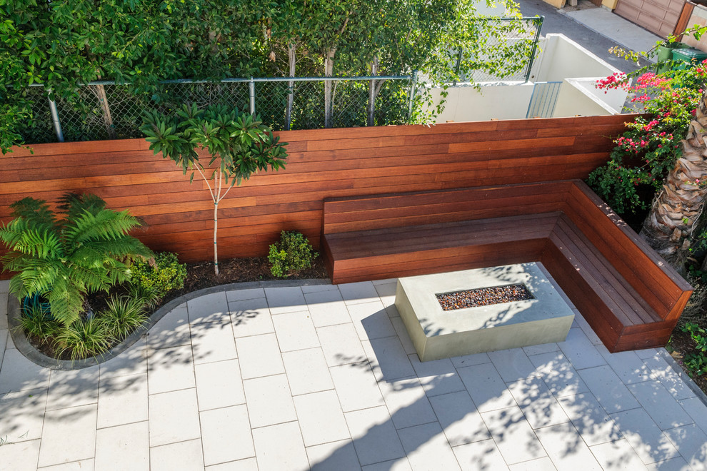 Idee per un patio o portico minimal di medie dimensioni e in cortile con un focolare e pavimentazioni in cemento