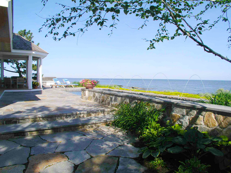 Beach style back patio in Bridgeport with a water feature, natural stone paving and a gazebo.