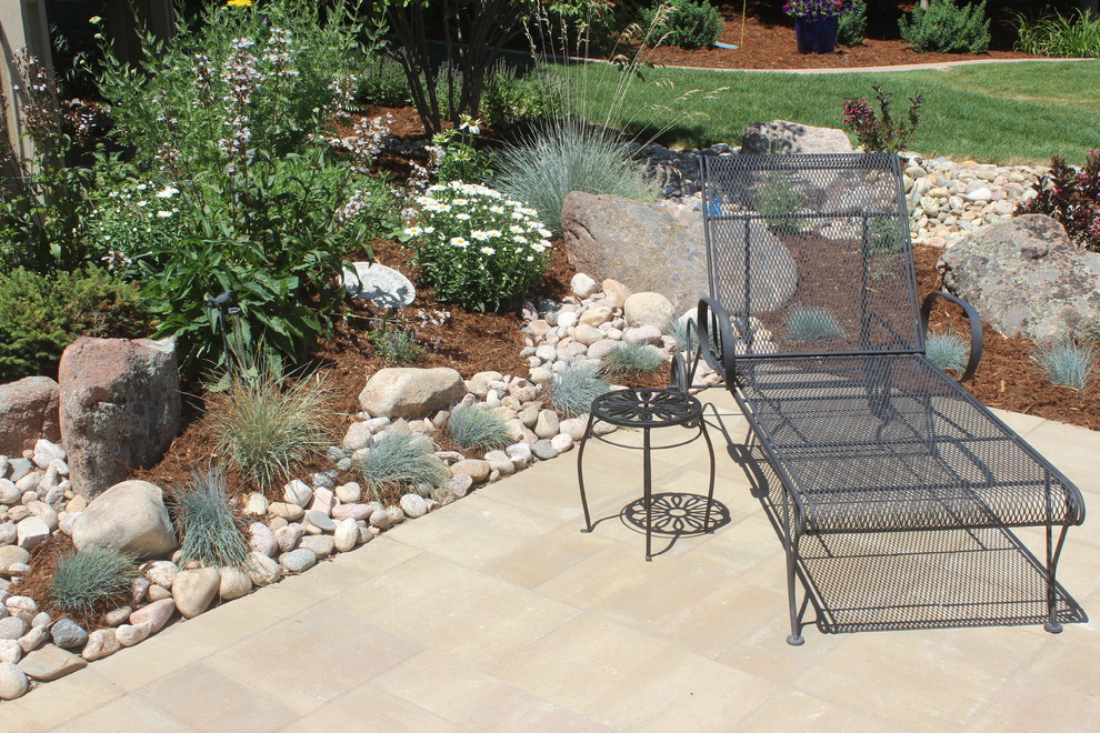 Elegant backyard concrete paver patio photo in Denver with an awning