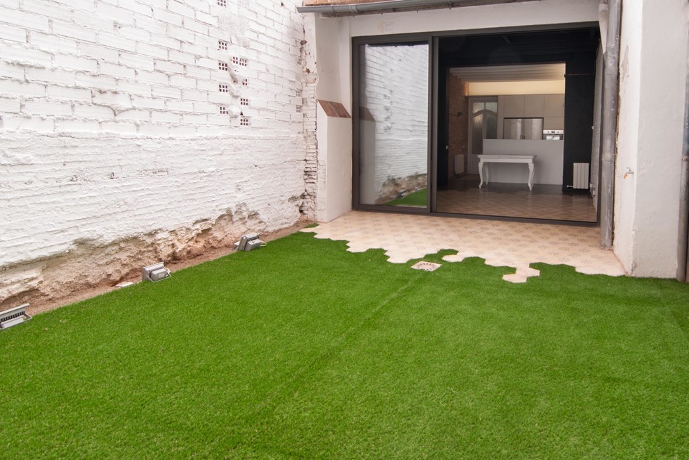 This is an example of a small industrial back patio in Barcelona with tiled flooring.
