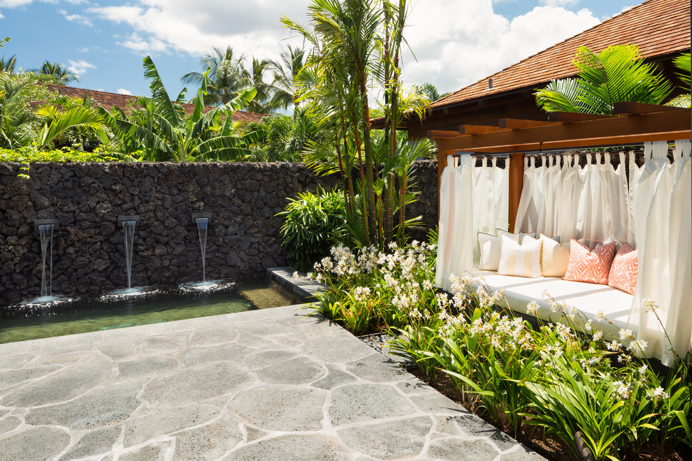 ハワイにあるラグジュアリーなトロピカルスタイルのおしゃれなテラス・中庭 (噴水) の写真