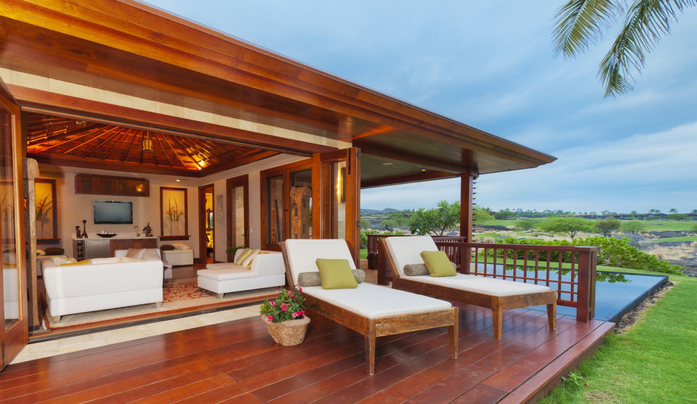 Exemple d'une terrasse en bois arrière exotique de taille moyenne avec une extension de toiture.