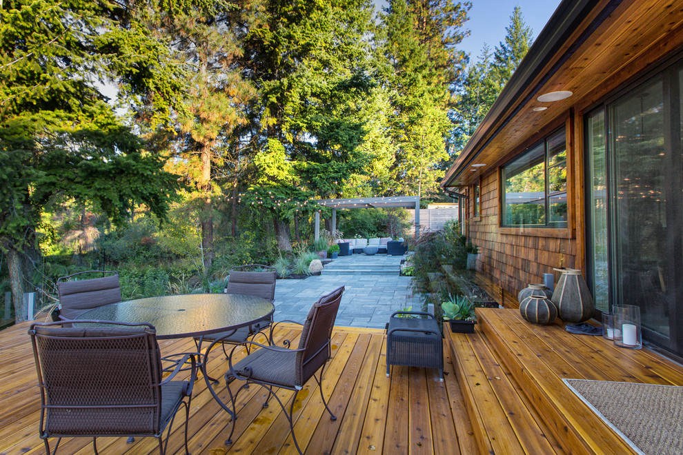 This is an example of a traditional patio in Vancouver with decking and a pergola.
