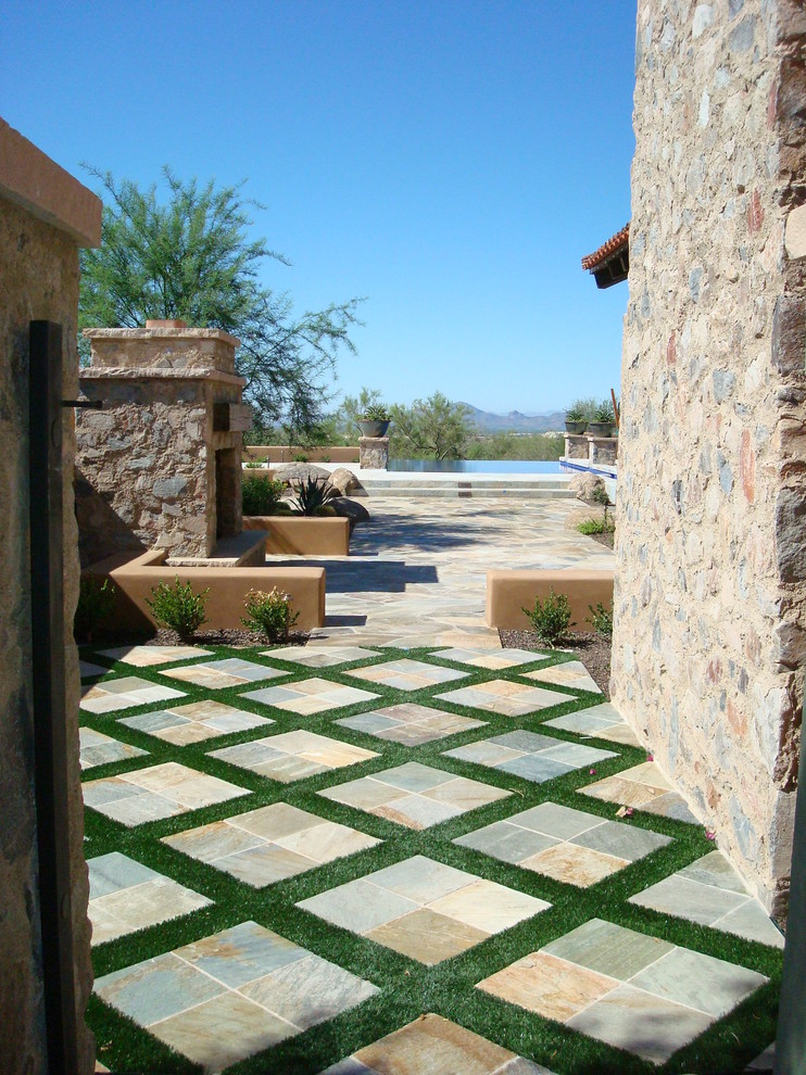 Example of a tuscan patio design in Phoenix with no cover