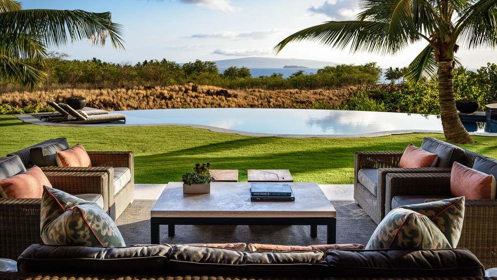 This is an example of a large world-inspired back patio in Hawaii with tiled flooring and a roof extension.