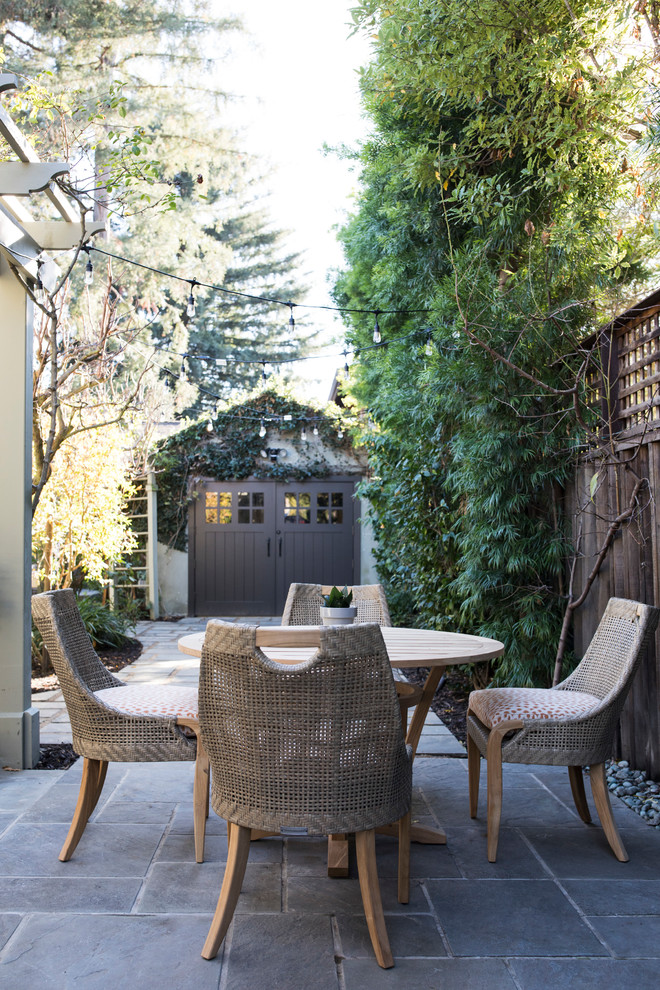 This is an example of a medium sized bohemian side patio in San Francisco with tiled flooring and a pergola.