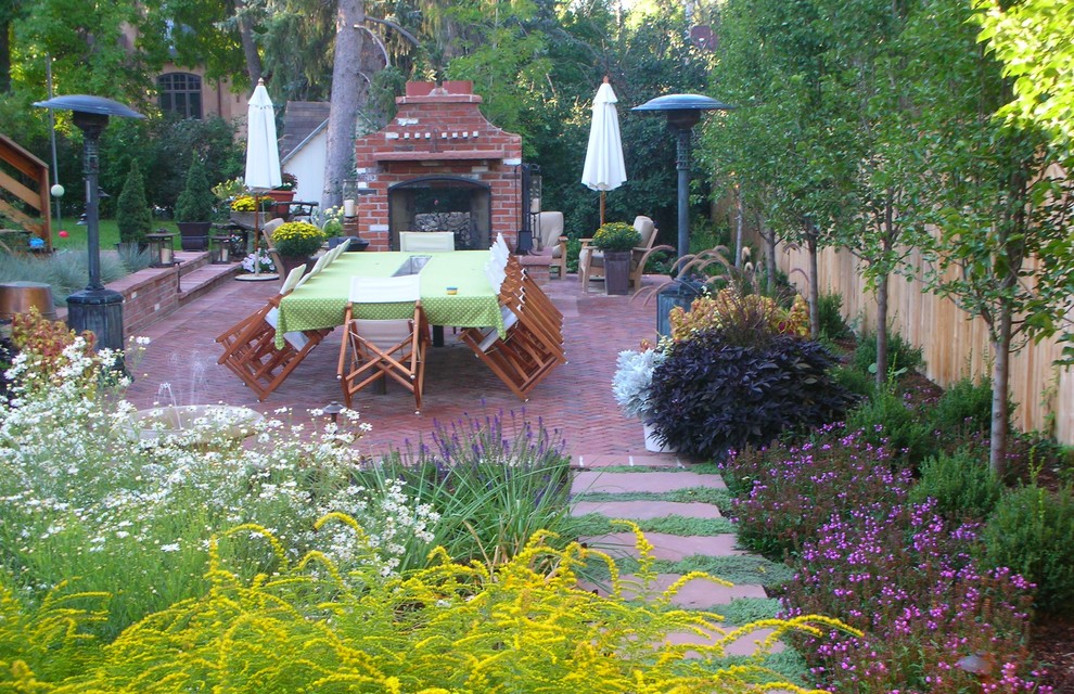 This is an example of a traditional back patio in Denver with brick paving.