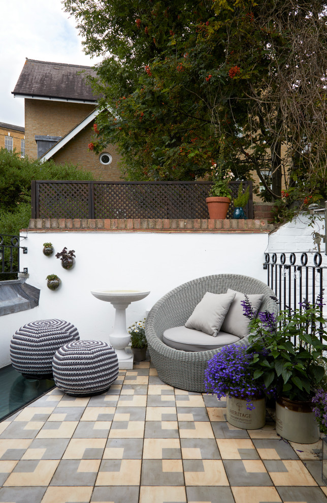 Small classic patio in London with no cover and tiled flooring.