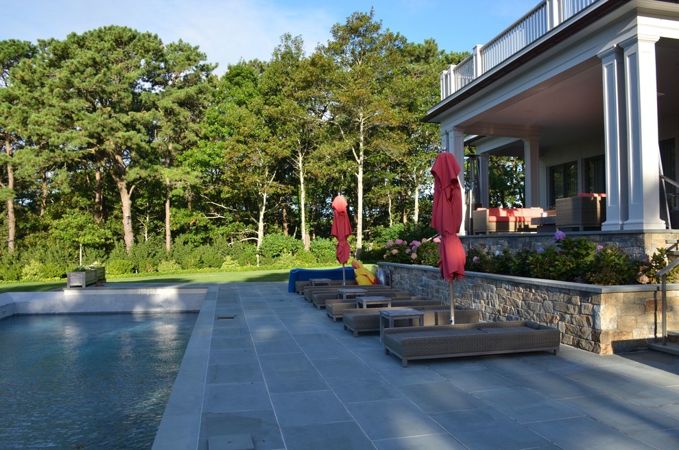 Foto di un ampio patio o portico tradizionale dietro casa con pavimentazioni in pietra naturale e una pergola