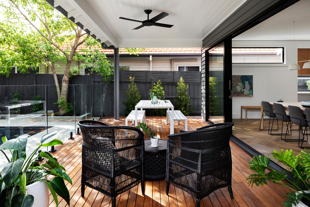 Example of a large trendy backyard patio design in Melbourne with decking and an awning