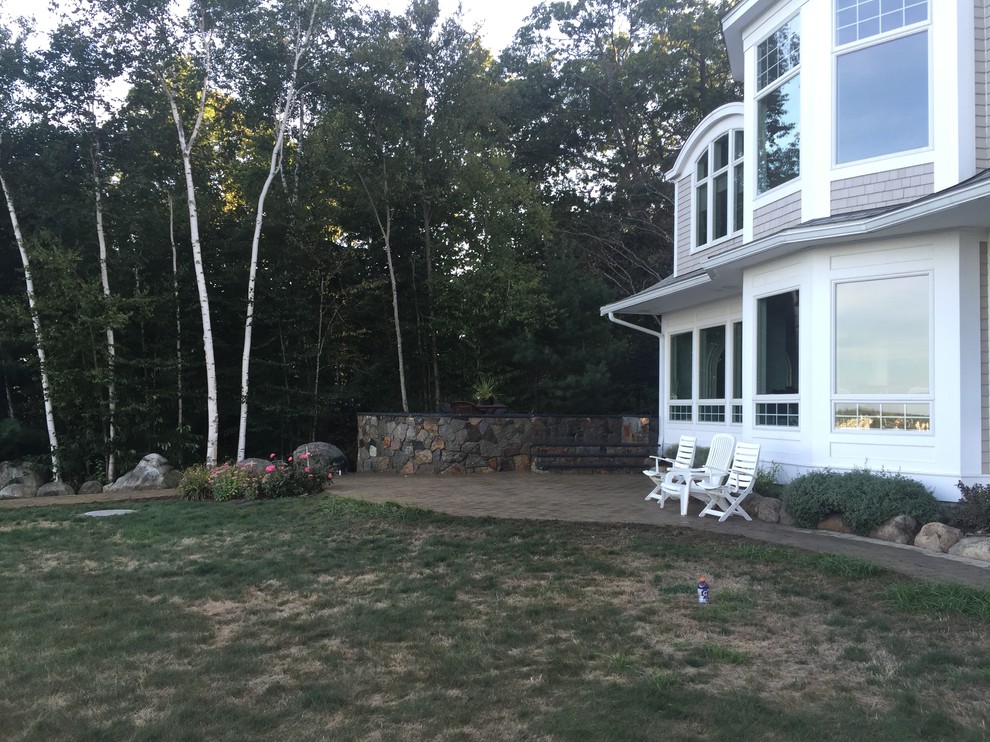 Example of a mid-sized classic backyard concrete paver patio design in Boston with no cover
