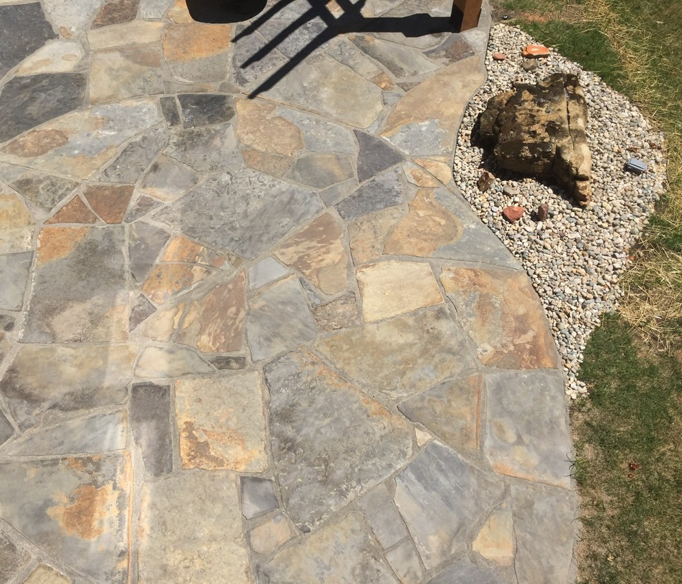 Modelo de patio en patio trasero con brasero, adoquines de piedra natural y pérgola