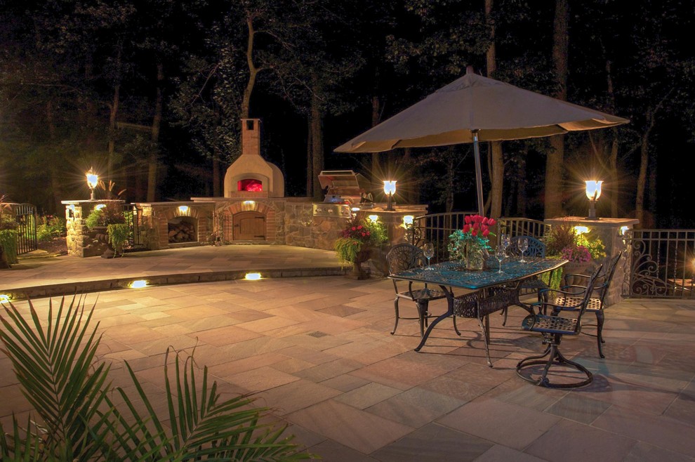 Cette image montre une terrasse arrière méditerranéenne de taille moyenne avec une cuisine d'été et des pavés en pierre naturelle.