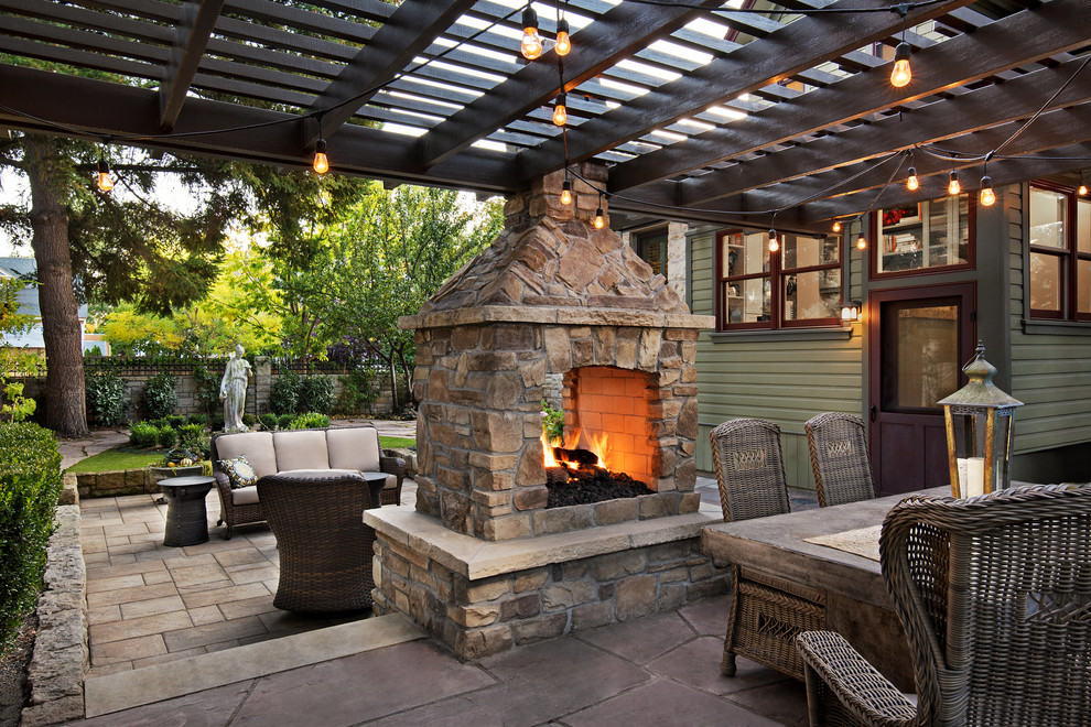 Imagen de patio clásico de tamaño medio en patio trasero con brasero, adoquines de piedra natural y pérgola