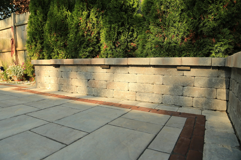 Idée de décoration pour une grande terrasse arrière tradition avec des pavés en béton.