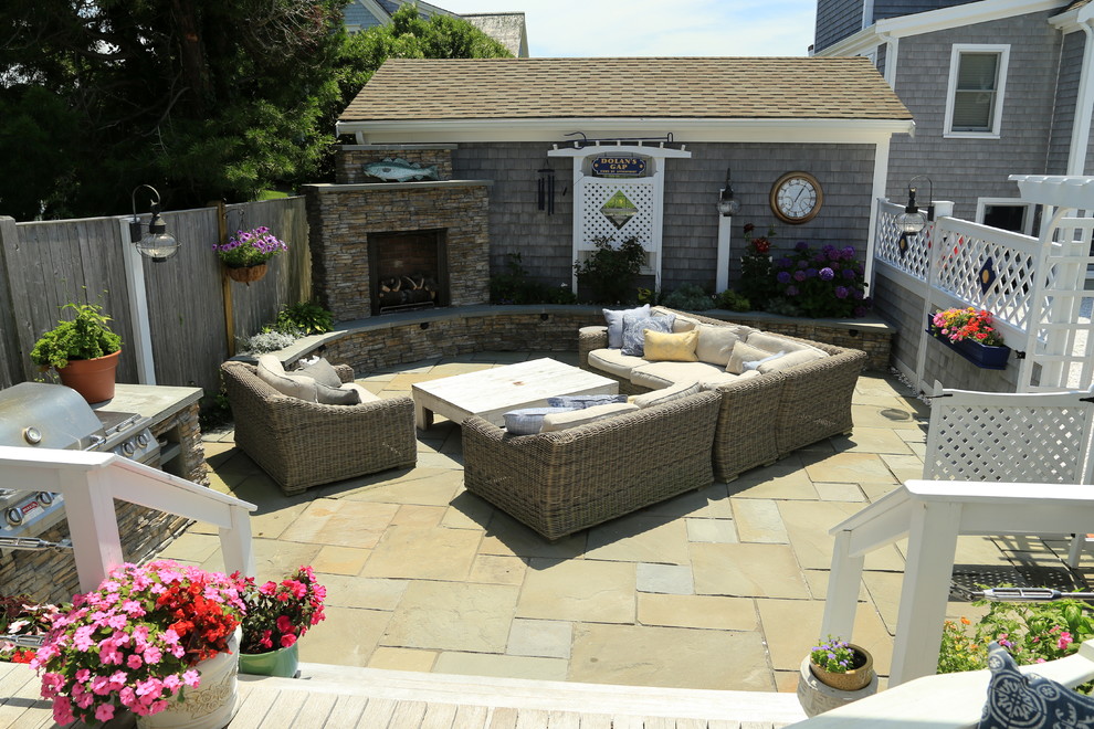 This is an example of a medium sized traditional patio in Boston with a fire feature and natural stone paving.