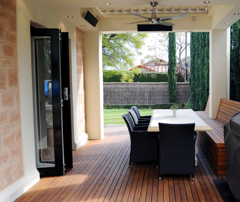 Cette photo montre une terrasse en bois latérale tendance de taille moyenne avec une cuisine d'été et une extension de toiture.