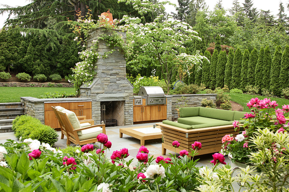 Elegant backyard stone patio photo in Seattle with no cover