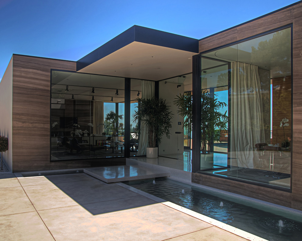 Photo of a medium sized contemporary back patio in Los Angeles with a roof extension.