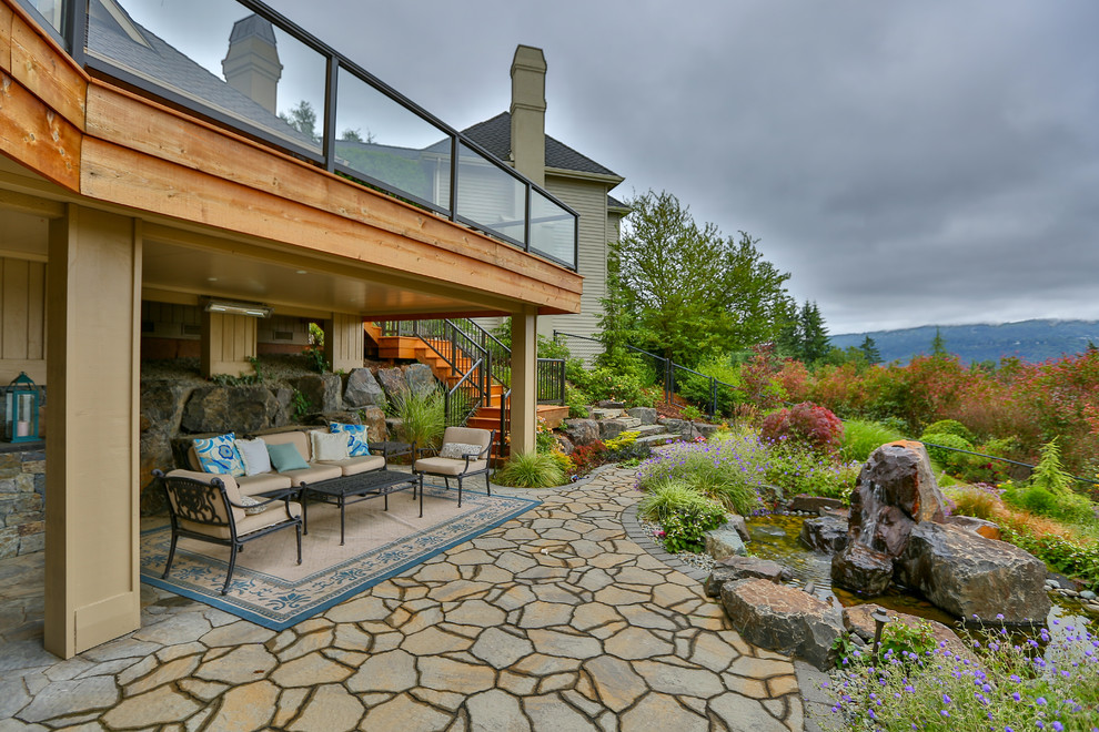 Aménagement d'une grande terrasse arrière moderne avec un point d'eau, des pavés en pierre naturelle et aucune couverture.