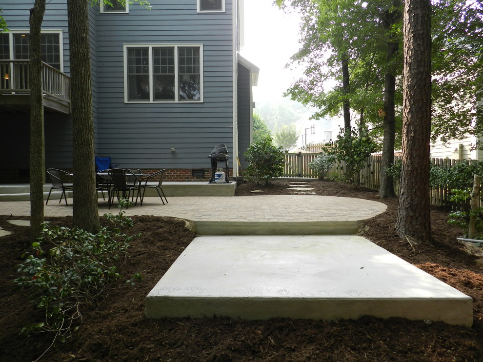 Small modern back patio in Raleigh with an outdoor kitchen, concrete paving and no cover.