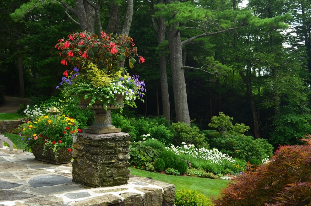 Design ideas for a huge traditional backyard stone landscaping in Other.