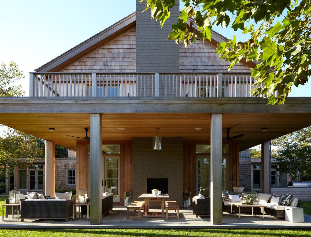 Ispirazione per un grande patio o portico tradizionale dietro casa con un tetto a sbalzo, piastrelle e un caminetto