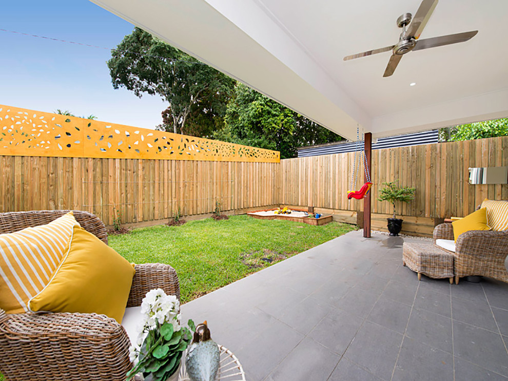 Example of a mid-sized trendy backyard tile patio design in Brisbane with a roof extension