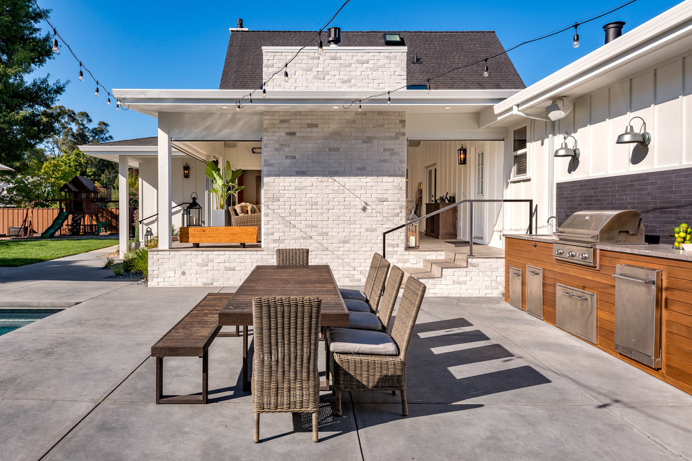 Ispirazione per un patio o portico country dietro casa con lastre di cemento