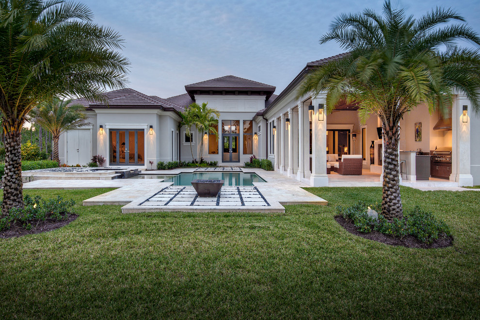 Large trendy backyard brick patio photo in Miami with a fire pit and a roof extension