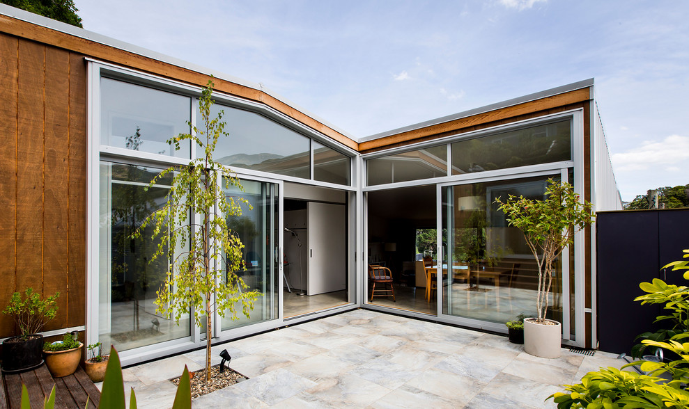 Cette photo montre une terrasse moderne avec une cour, des pavés en pierre naturelle et aucune couverture.