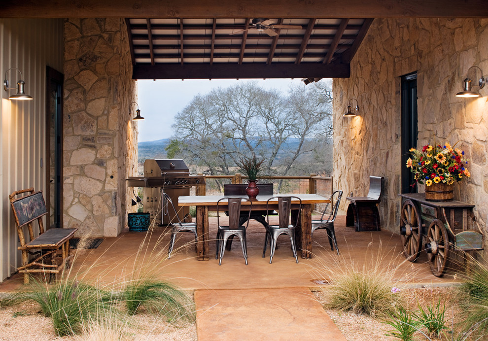 Example of a mountain style courtyard patio design in Austin with a roof extension