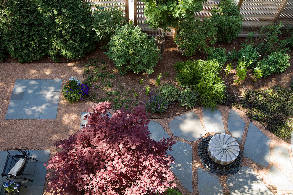 Foto de patio clásico renovado de tamaño medio sin cubierta en patio trasero con fuente y granito descompuesto