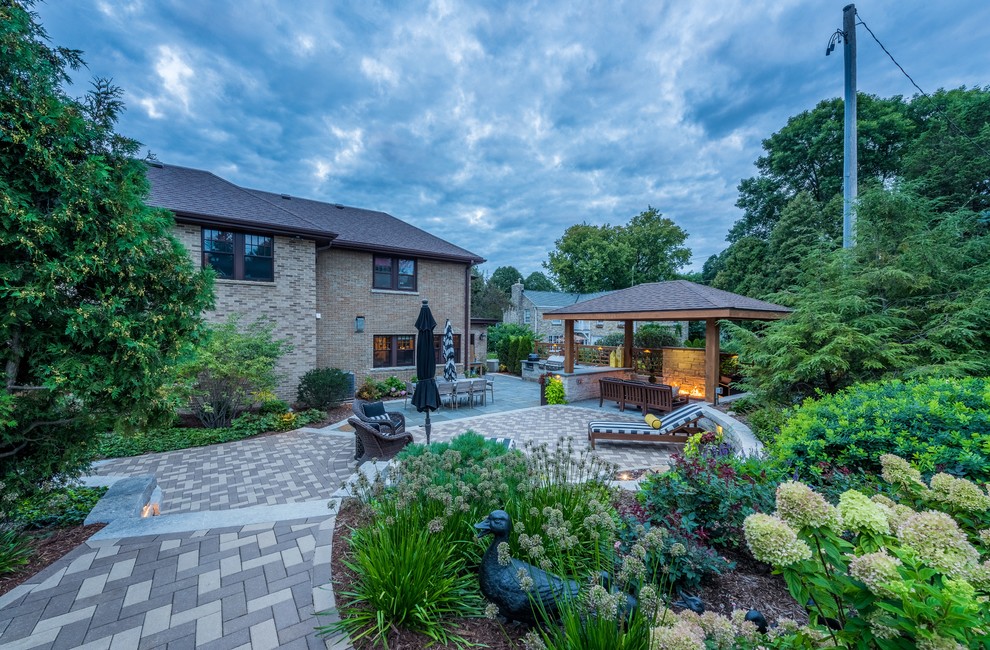 Inspiration for a large timeless backyard brick patio remodel in Milwaukee with a gazebo and a fire pit