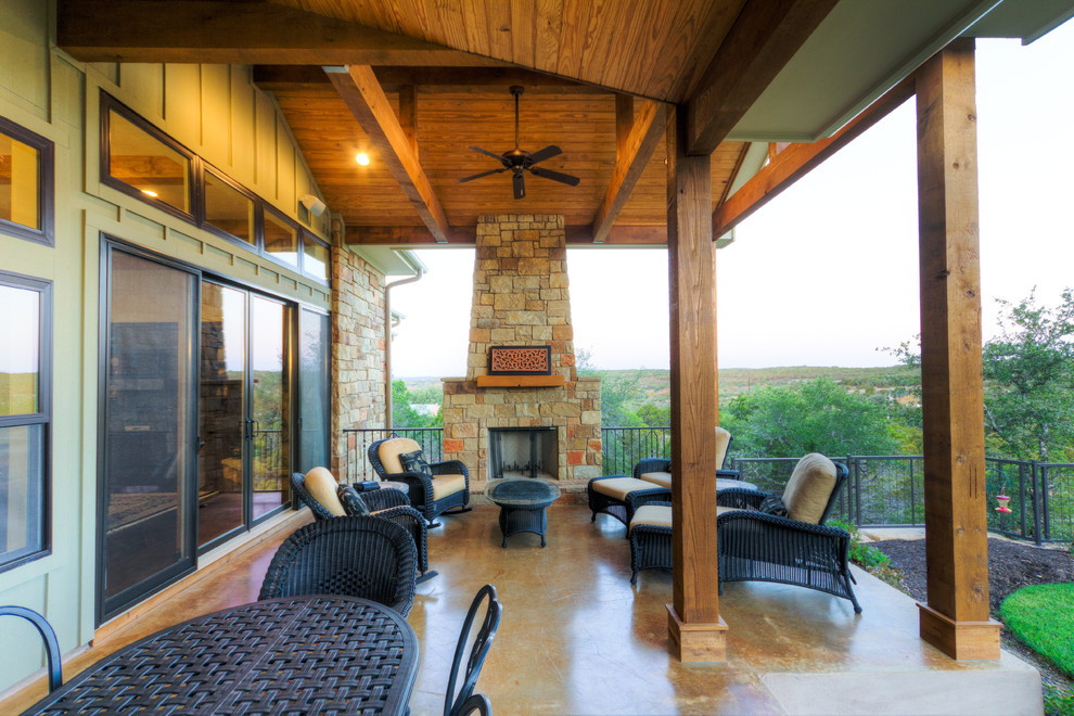 Patio - mid-sized craftsman backyard concrete patio idea in Austin with a fireplace and an awning