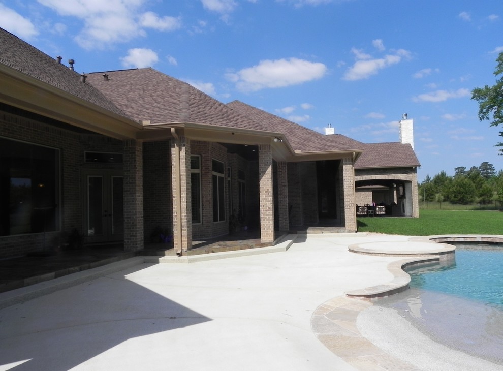 Expansive rustic back patio in Houston with an outdoor kitchen, natural stone paving and a roof extension.