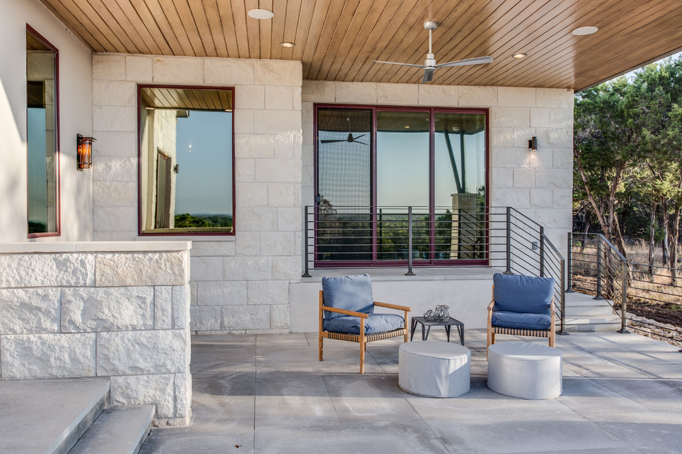 На фото: большой двор на боковом дворе в современном стиле с местом для костра, покрытием из декоративного бетона и навесом