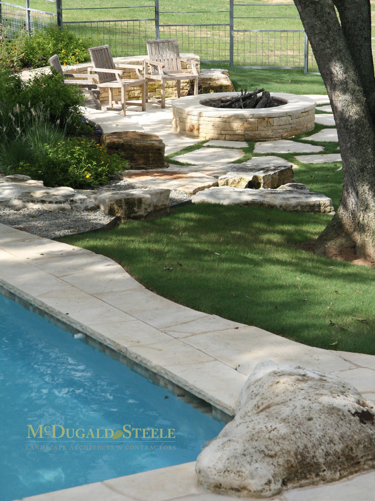 Bohemian patio in Houston with a fire feature and natural stone paving.