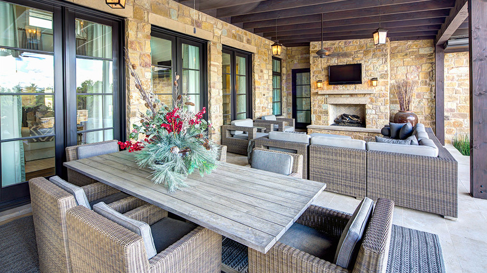 Design ideas for a large mediterranean back patio in Austin with a fireplace, tiled flooring and a roof extension.
