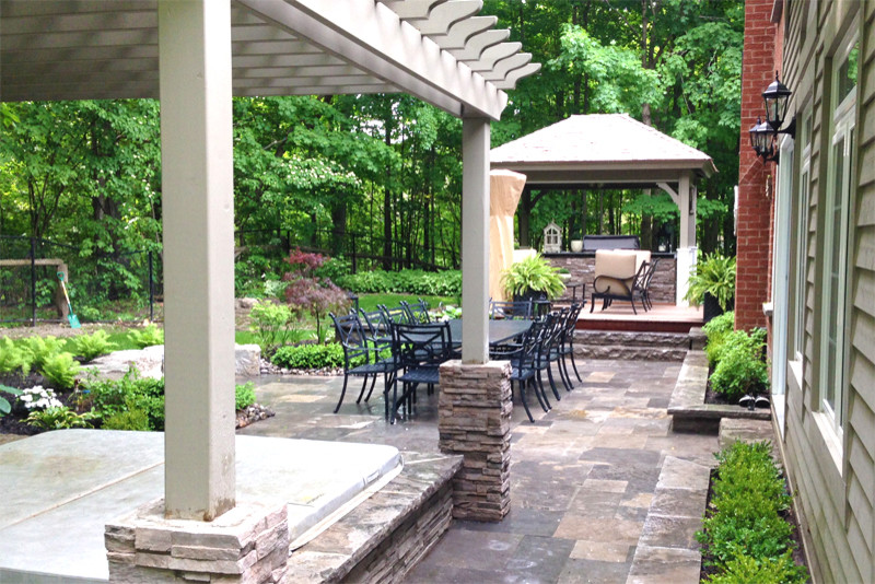 Example of a mid-sized classic backyard stone patio kitchen design in Toronto with a pergola