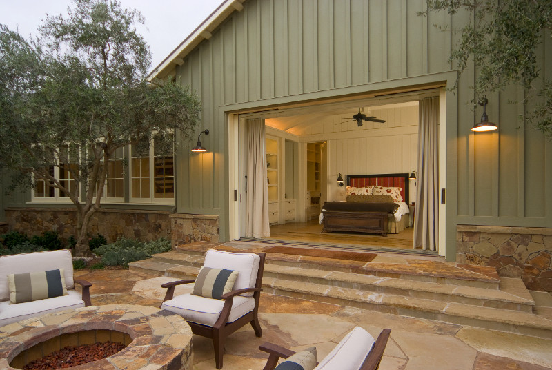 Foto de patio de estilo de casa de campo grande sin cubierta en patio trasero con brasero y adoquines de piedra natural