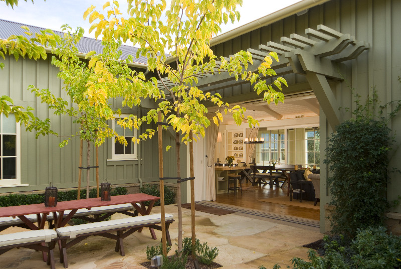 Imagen de patio de estilo de casa de campo grande en patio trasero con brasero, adoquines de piedra natural y pérgola