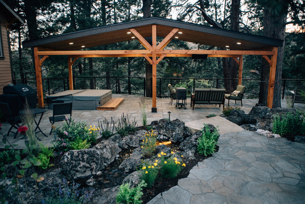 Immagine di un grande patio o portico american style dietro casa con pavimentazioni in pietra naturale e un gazebo o capanno