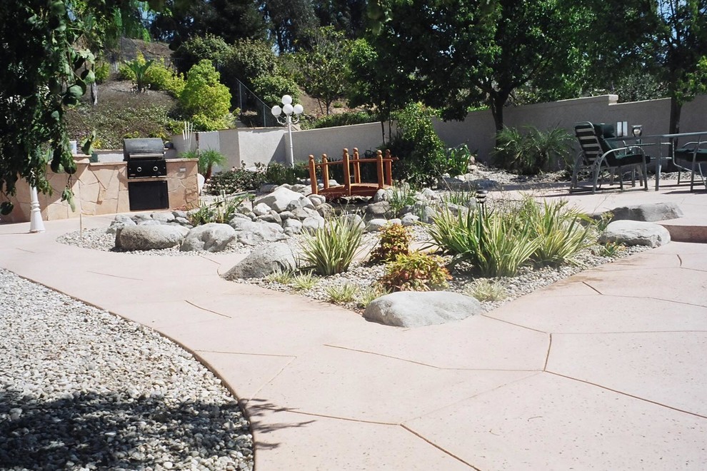 Mid-sized elegant backyard stone patio kitchen photo in Santa Barbara with no cover