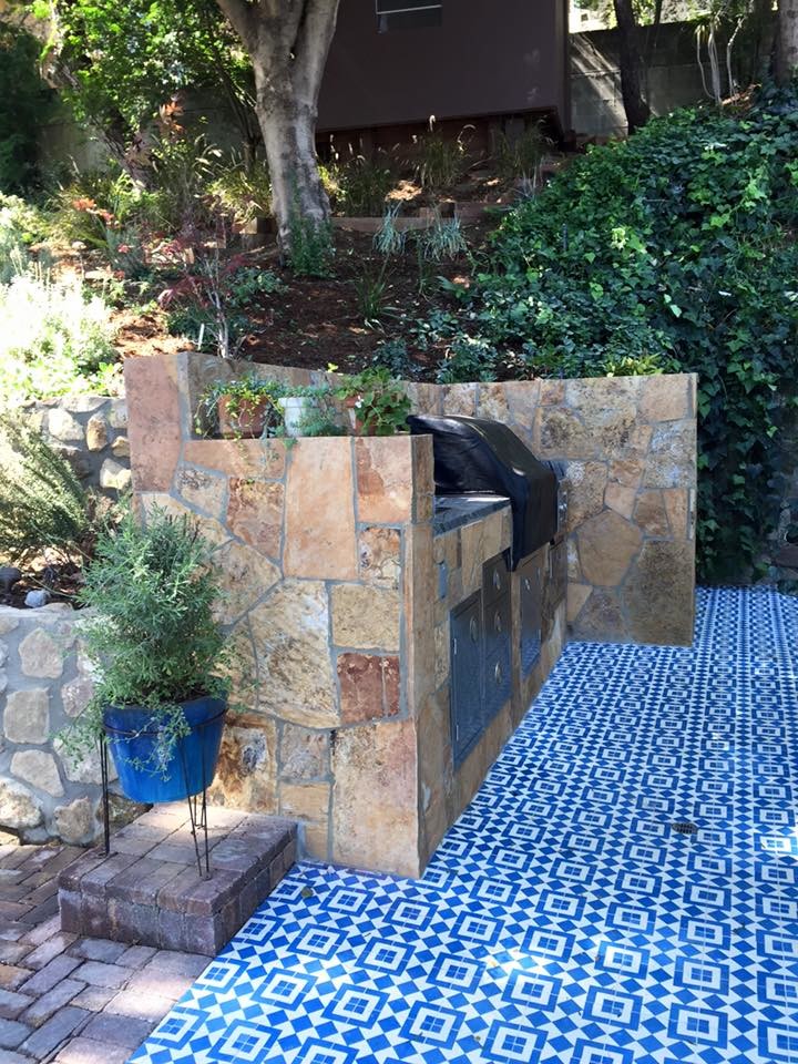 Ejemplo de patio contemporáneo de tamaño medio sin cubierta en patio trasero con cocina exterior y adoquines de piedra natural
