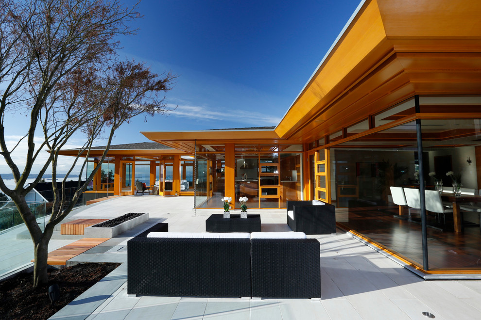 Imagen de patio contemporáneo grande sin cubierta en patio trasero con brasero y adoquines de hormigón