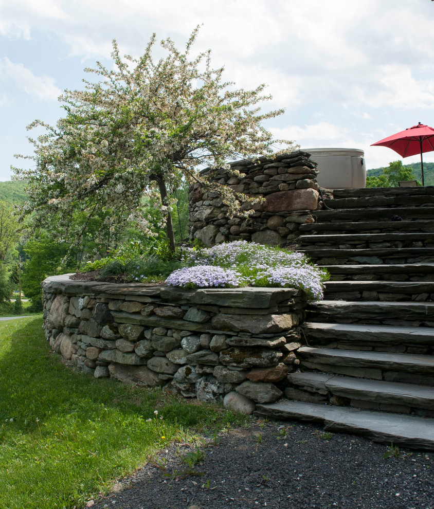 Inspiration pour une grande terrasse arrière rustique avec des pavés en pierre naturelle.