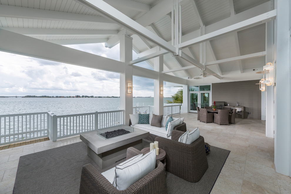 Large nautical back patio in Tampa with a fire feature, tiled flooring and a roof extension.