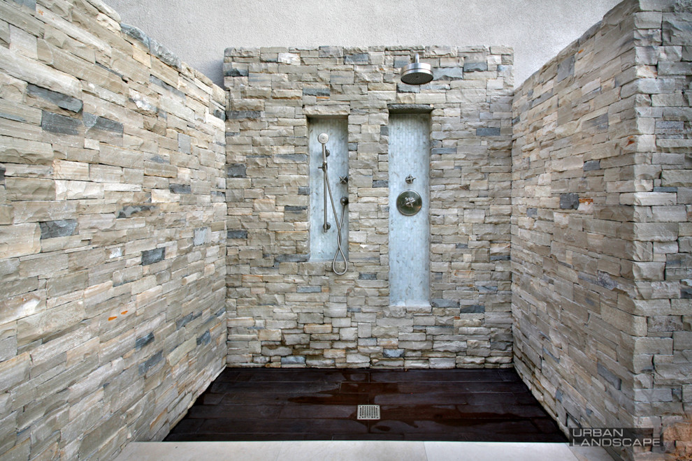 Example of a mid-sized minimalist backyard stone patio fountain design in Orange County with a pergola