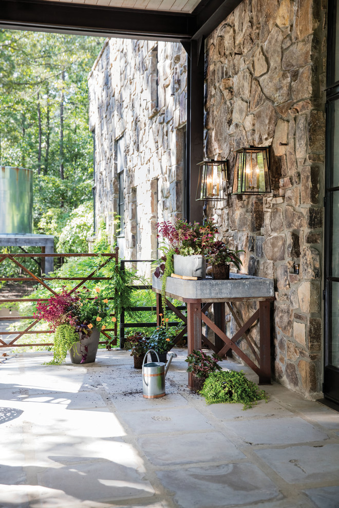 На фото: двор среднего размера на заднем дворе в современном стиле с растениями в контейнерах, покрытием из каменной брусчатки и навесом
